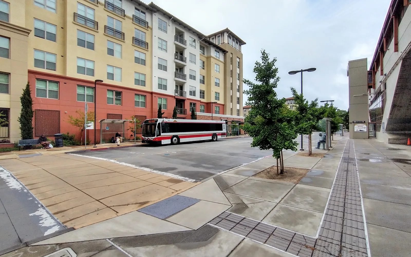 Transit-oriented development at Pleasant Hill BART station showing bus, multi-story residential housing, and retail integration